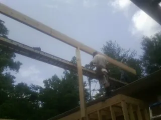 Carpenter setting a ridge beam over a new addition frame — Ice Dam Removal by Roofing Brothers in Sheffield Lake