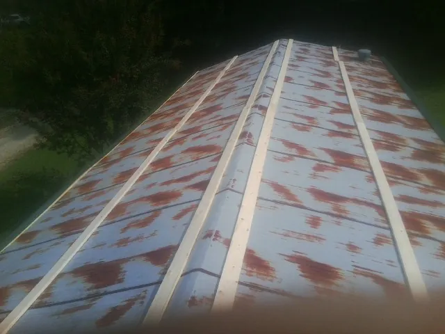 Rusted metal roof panels with new wood purlins before replacement — Storm Damage Roof Repair in Sheffield Lake by Roofing Brothers