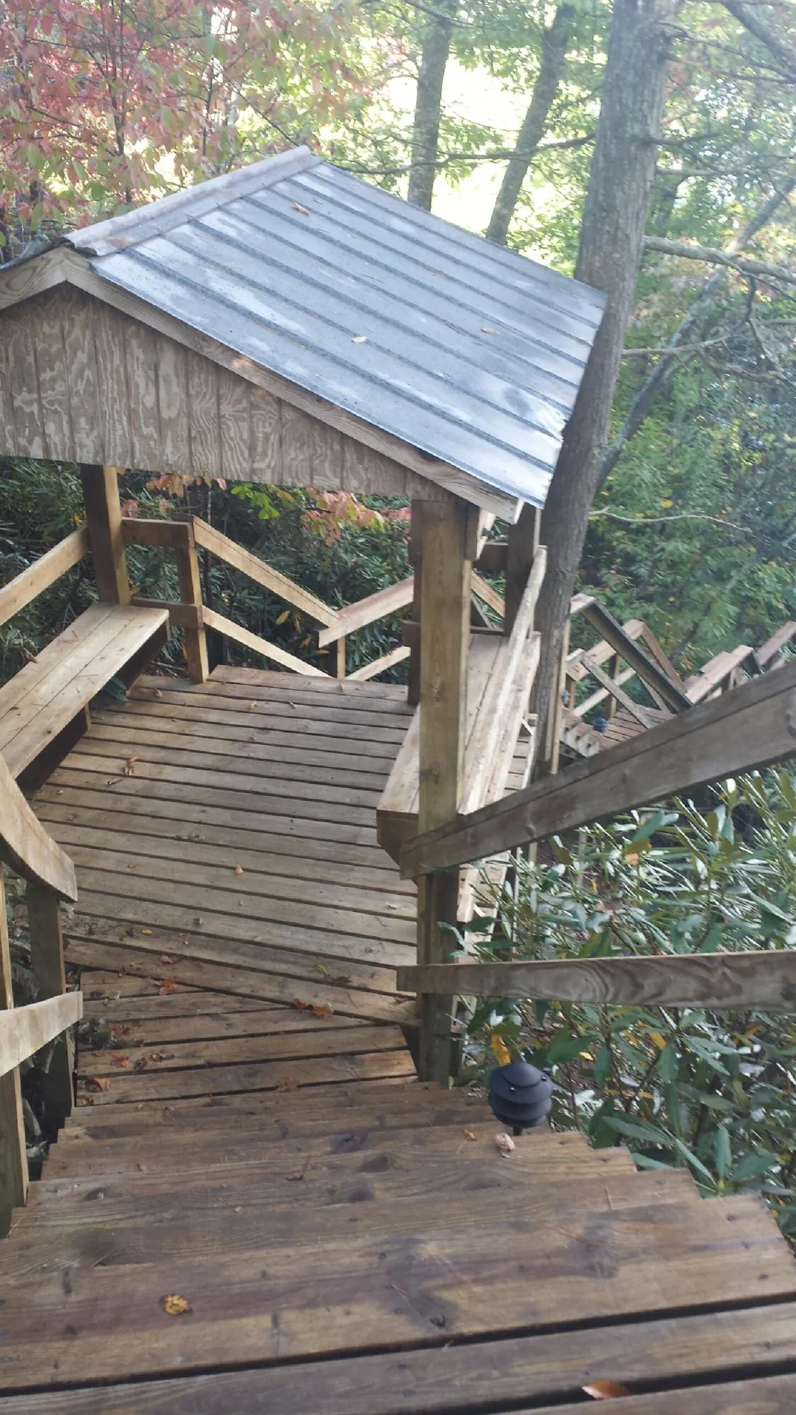 Metal roofed shelter over wooden steps on a wooded walkway — Skylight Repair & Installation work by our crew in Sheffield Lake